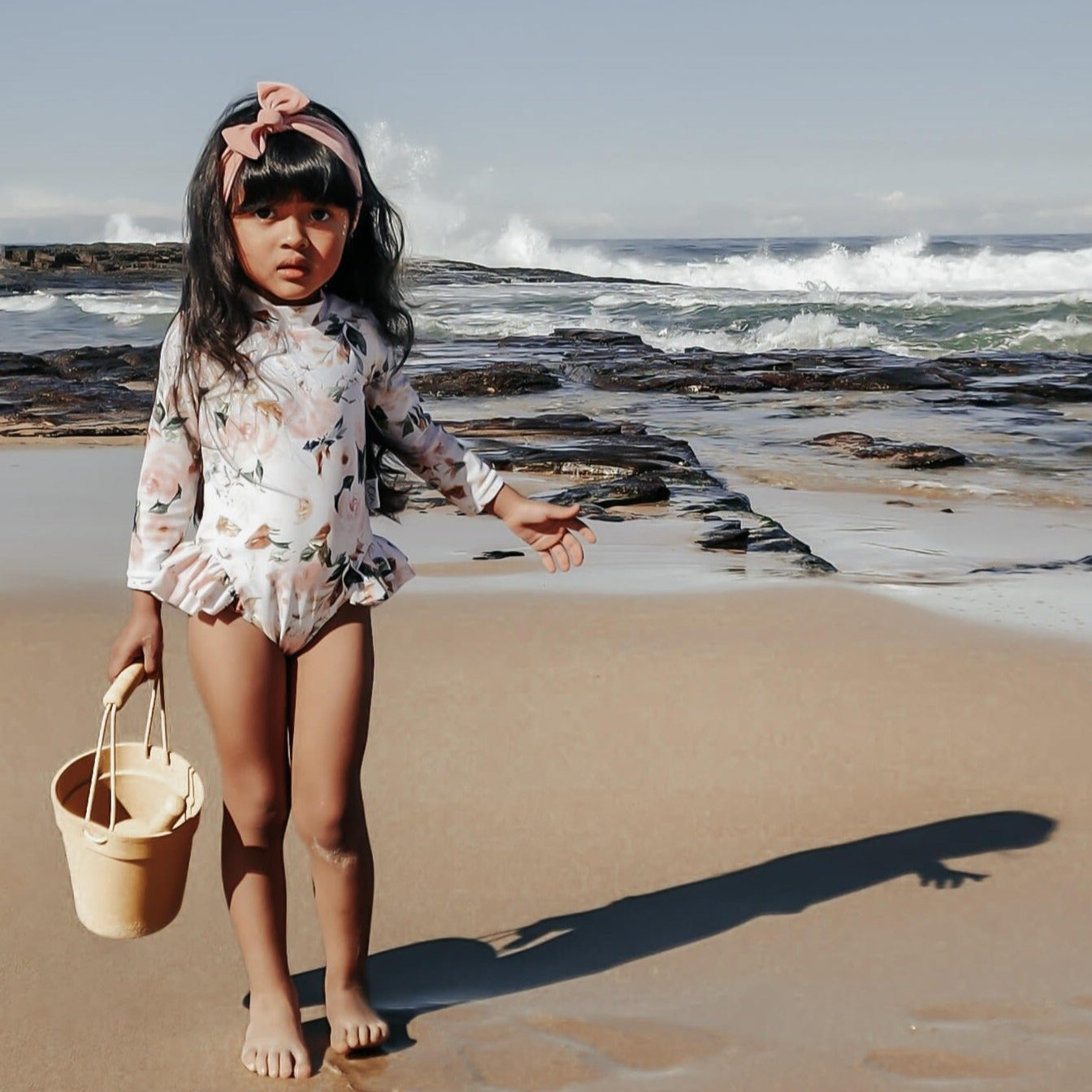 kids swimwear, young girl at the beach in a swimsuit with nappy  changing snaps