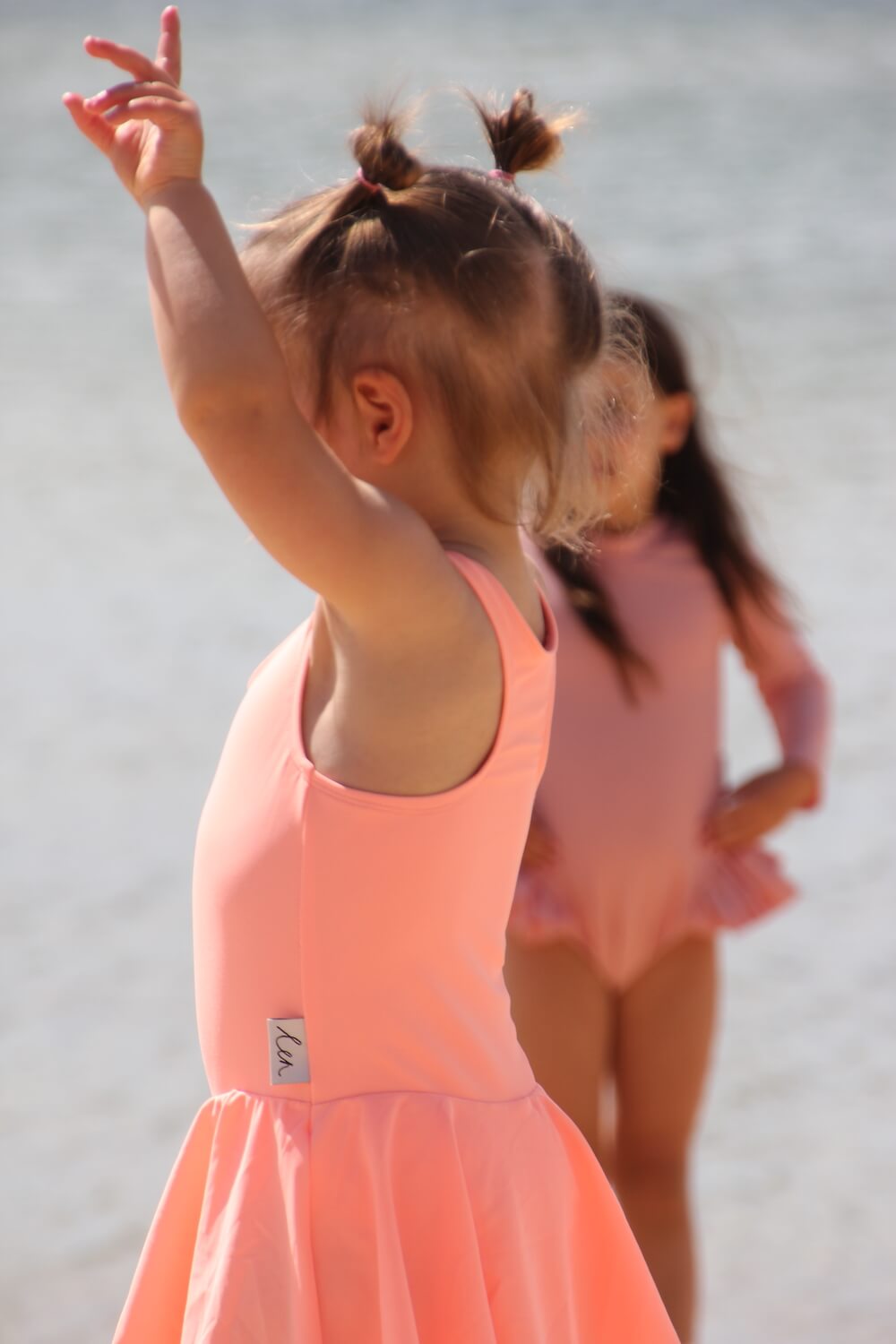 Kids on the beach wearing Len Swim pink swimwear