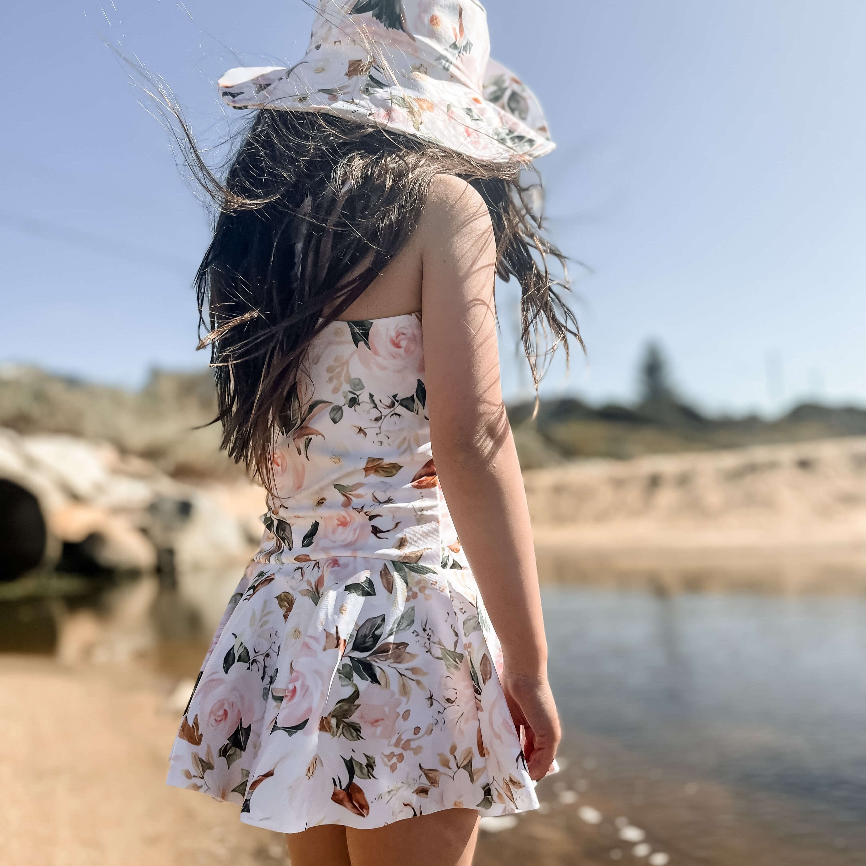 girl in a ballerina style swimsuit dress with change snaps and a matching swim hat