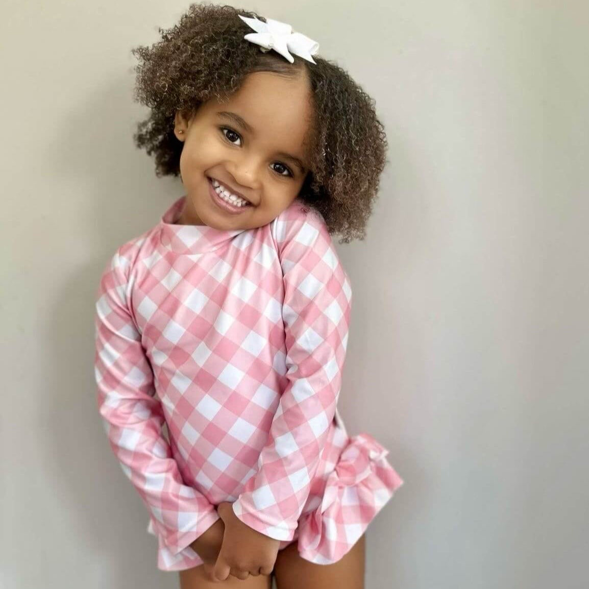 young girl wearing a swimsuit with change snaps in a pink gingham 