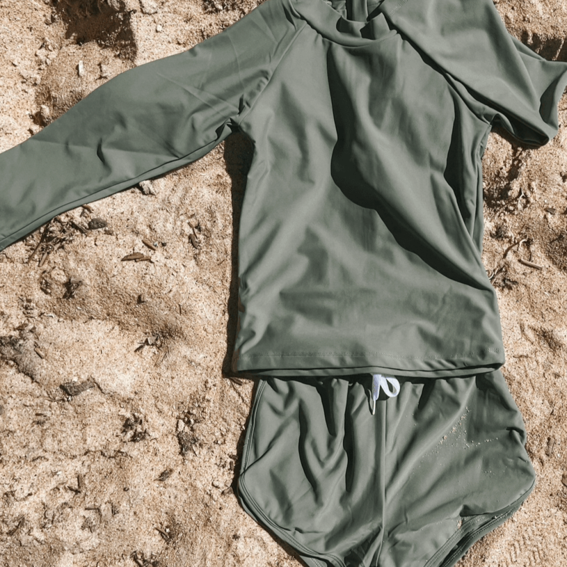 Olive rash set for girls and boys and babies laying flat on the sand