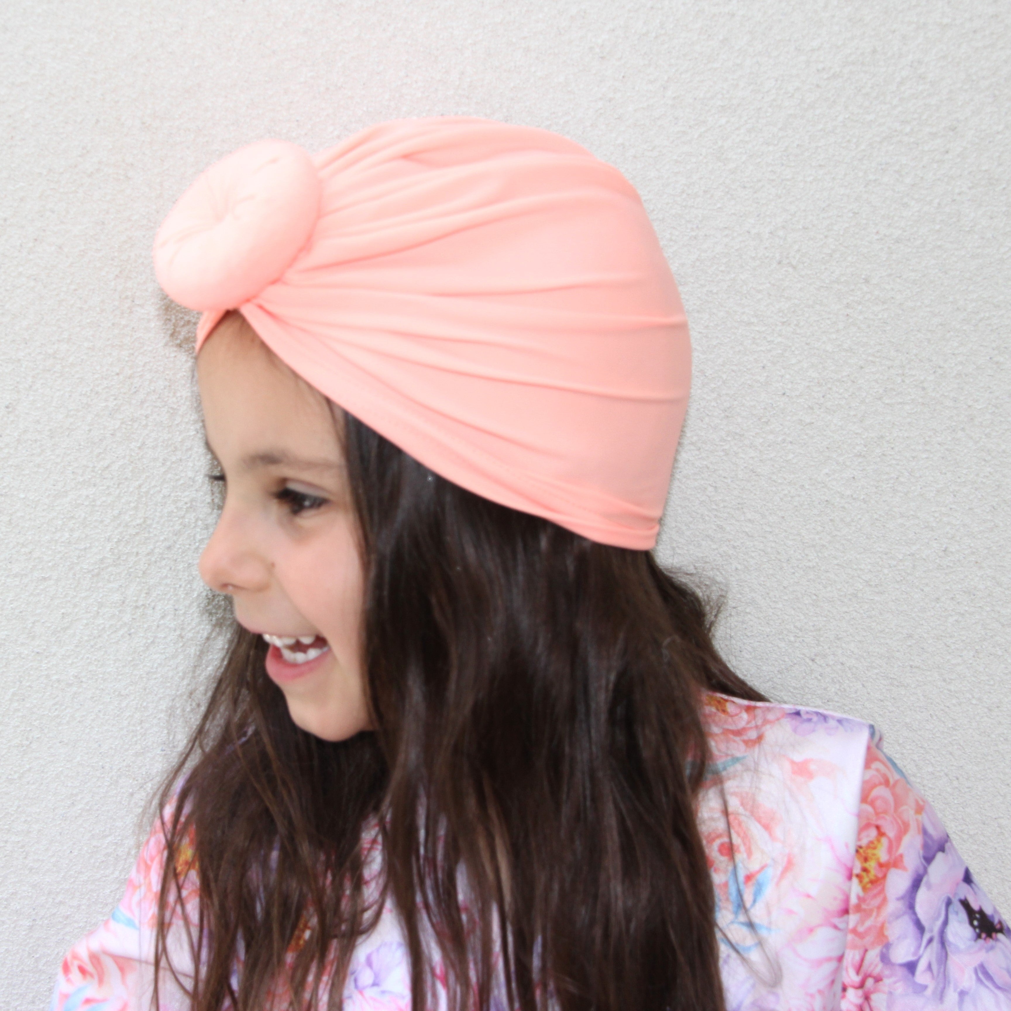 Young girl wearing orange tangering swim turban 